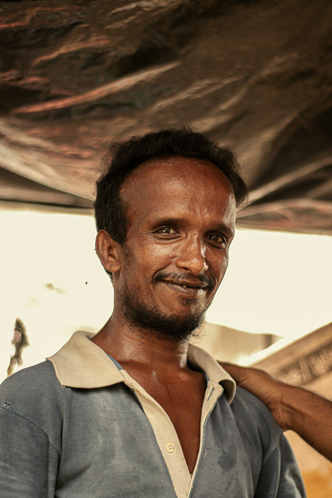 Portrait of a man in a blue shirt smiling