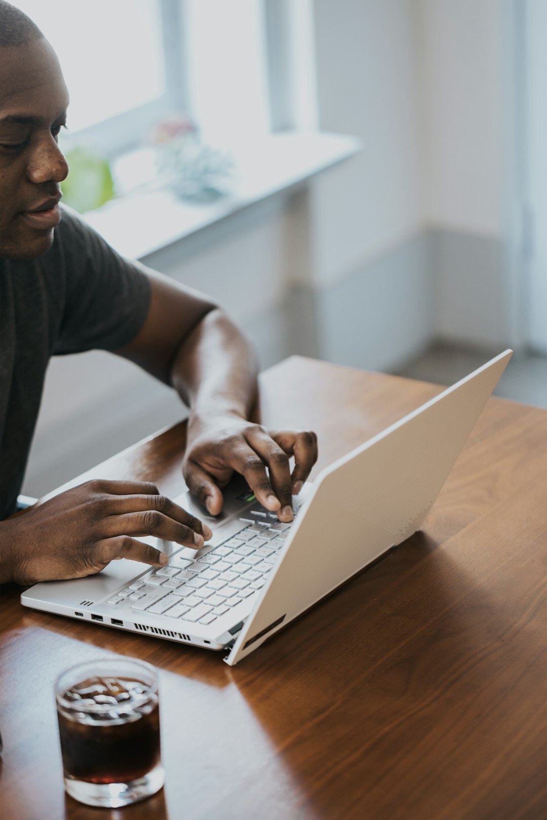 Man typing on a laptop during an online discussion